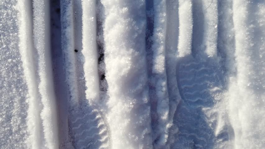 Footprints in the crystallized snow in northern Europe on a sunny morning in January.