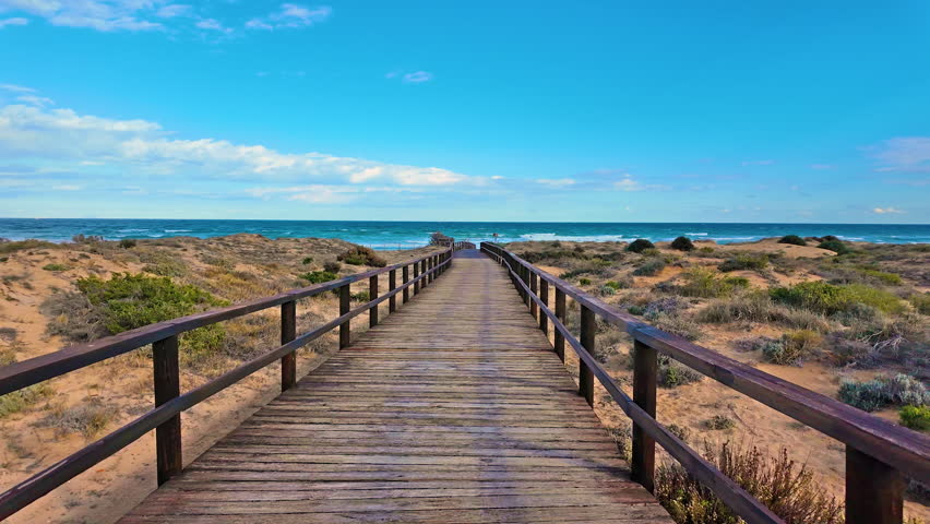 Walking to the blue sea on a wooden road