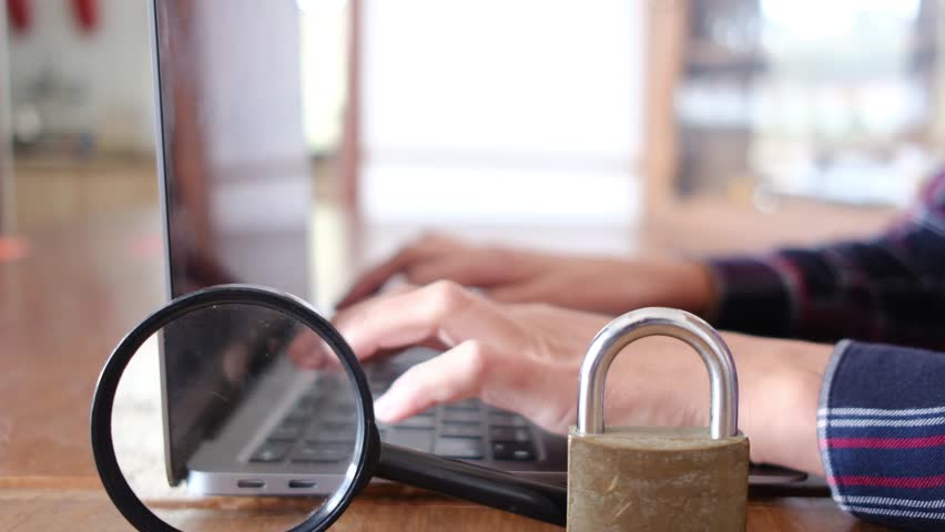 Magnifying glass padlock laptop security i person working with a laptop at his desk. Security, search, transaction, data, digital banking, artificial intelligence on the internet. Royalty-Free Stock Footage #3416716159