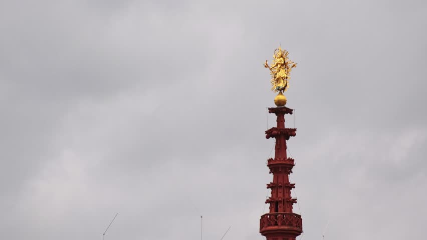 Huge Madonna sculpture turning by the wind. The 3.45 meter tall sculpture covered in gold and stays on the top of the Marienkapelle located at the Market Square of the town of Würzburg, Bavaria.