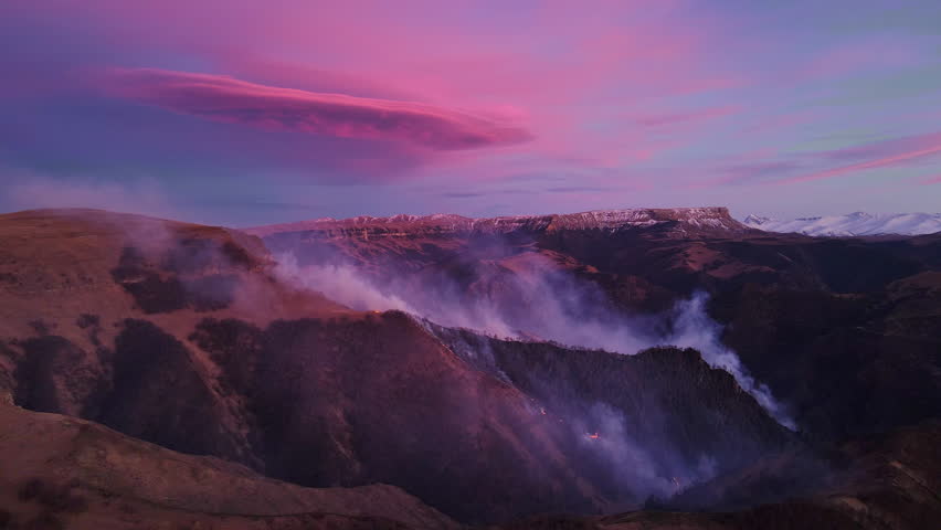 Majestic northern mountains under bright purple sky aerial top view. Purple sky illuminating evening enhancing mountain beauty Purple sky over mountains symbol of nature