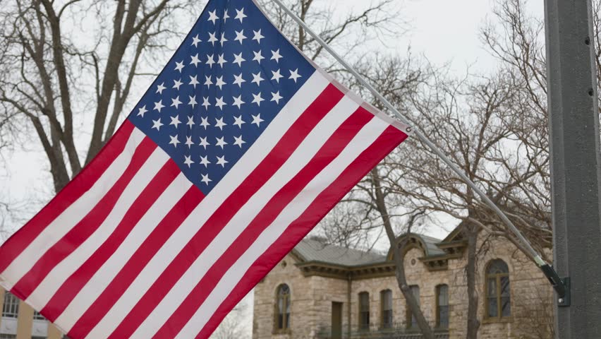 US flag blowing in the wind on a cloudy day