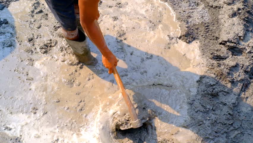 Industrial Videography. Construction Works. Footage of construction workers mixing cement mixture with a hoe. Mix cement with water, sand and coral stone. Bandung, Indonesia Royalty-Free Stock Footage #3416912205