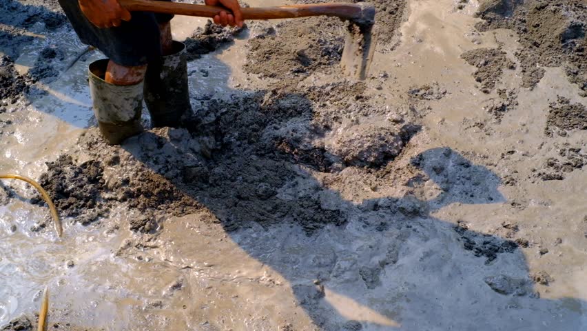 Industrial Videography. Construction Works. Footage of construction workers mixing cement mixture with a hoe. Mix cement with water, sand and coral stone. Bandung, Indonesia Royalty-Free Stock Footage #3416912703