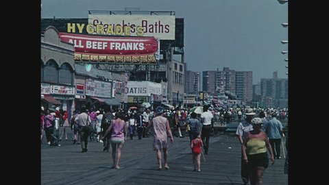 NEW YORK, 1971, Boardwalk crowded with people, Frankfurter and Bathhouse sign at Coney Island, Brooklyn