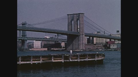 NEW YORK, 1971, The Brooklyn Bridge across the East River with piers medium shot