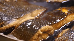 A video of pouring broth into simmering flounder. A flounder with an egg inside.