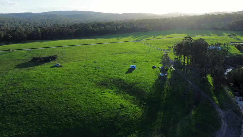 Drone aerial afternoon sunset campervan on grass farm property meadow paddock camping farmland Eden Nethercote South Coast Australia Royalty-Free Stock Footage #3417215859