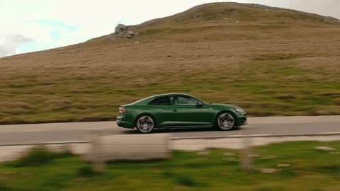 Establishing aerial rolling shot of luxury coupe sport car driving on o mountain road. Car driving fast on the road , videoclip de stoc