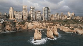Waves crash on large rocks near the coast ob Beirut, Lebanon. Aerial video, panoramic view.