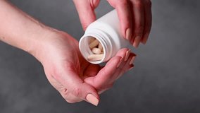 Female hands holding a heap of white capsules, Collagen, vitamins, pain killers, food supplements pills. - Powered by Shutterstock - Get 15% off with code: PIKWIZARD15