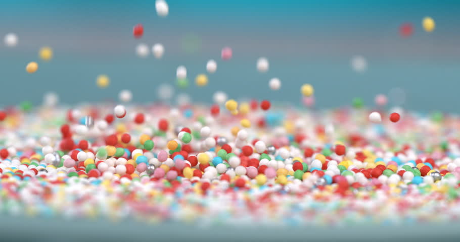 Super slow motion extreme macro of sweet rainbow sugar sprinkles are falling on delicious dessert pink glazed donuts isolated on soft colorful background at 1000 fps.