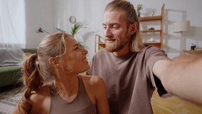 First person view of friendly sporty spouse resting after training and having video call in cozy room. Caucasian woman and man using modern gadgets for online communication indoors. - Powered by Shutterstock - Get 15% off with code: PIKWIZARD15
