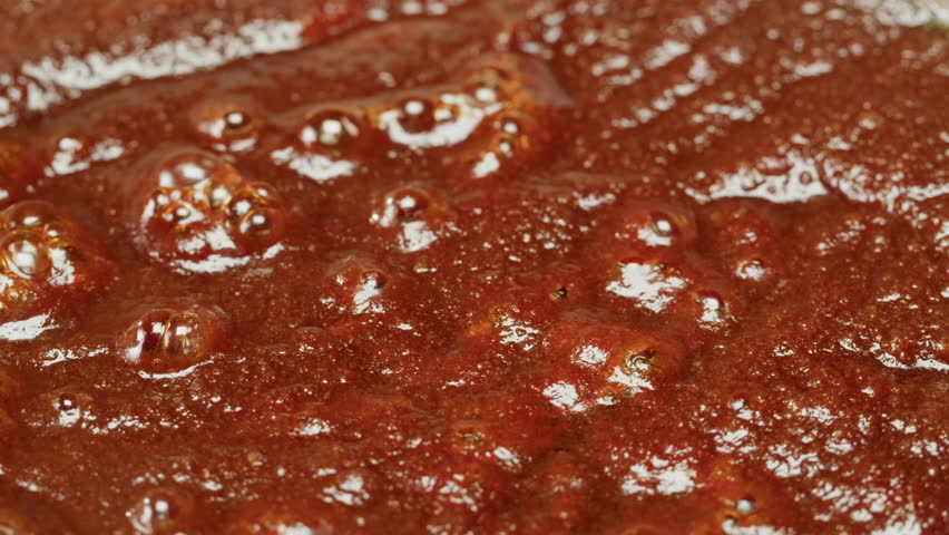 Close up of boiling sugar with bubbles turns into caramel, caramelization, making berry jam at home close-up. Chef cooking dessert in cafe, restaurant pastry food.