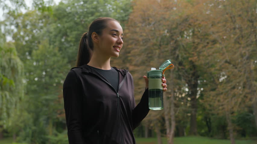 Sport woman Caucasian fitness girl after workout in city park drink bottle fresh water happy female sportswoman healthy food diet loss weight eat green apple vegetarian nutrition health care lifestyle