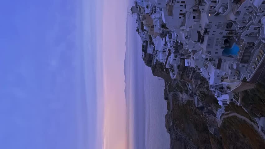Famous Oia village in Santorini, Greece, at violet sunset - panning