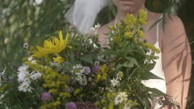 A girl holds a bouquet of flowers in her hands and looks around