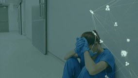 Animation of network of medical icons over stressed caucasian female surgeon sitting on floor. Medical services, healthcare, digital interface, networks and communication, digitally generated video. - Powered by Shutterstock - Get 15% off with code: PIKWIZARD15