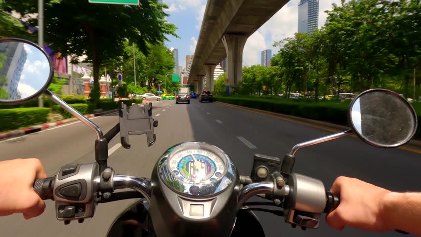 Hyperlapse of motorcycle riding in road traffic next to BTS Skytrain in Bangkok, Thailand. POV