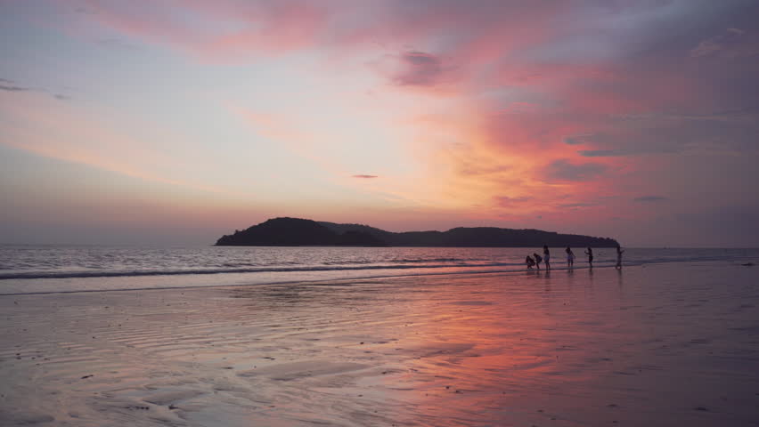 Awesome sunset view of Cenang Beach (Pantai Cenang) on Langkawi island in Malaysia. Colorful sky is reflected in the sea and wet sand. Amazing seascape.