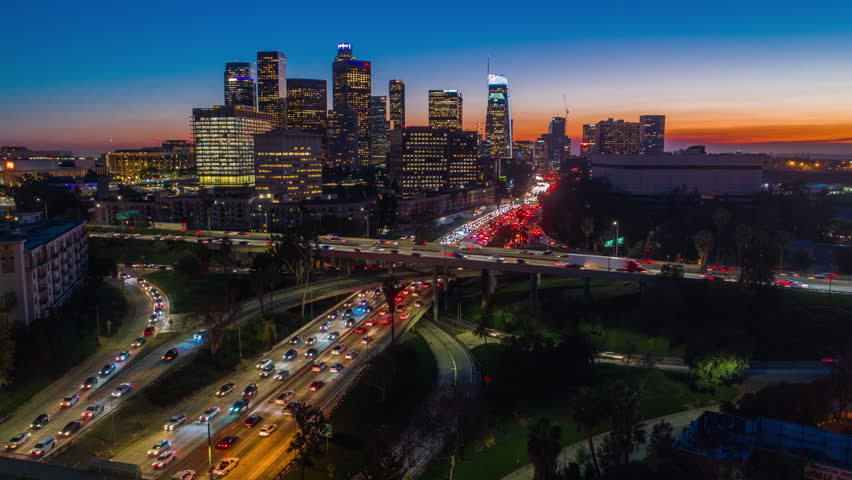 Cinematic urban aerial hyperlapse of downtown Los Angeles freeways and traffic with city skyline and skyscrapers at sunset with deep blue and orange colors. | Shutterstock HD Video #34177435