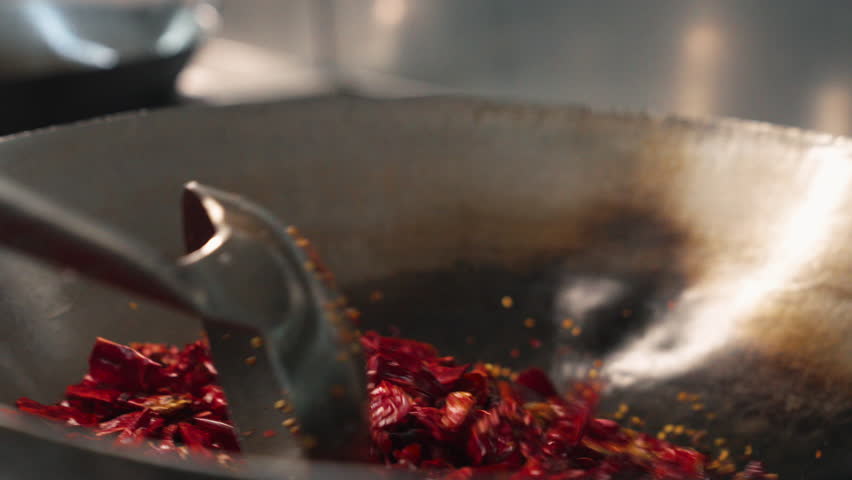 Sizzling Sichuan Delight: Close-Up of Red Peppers Stir-Frying in Wok