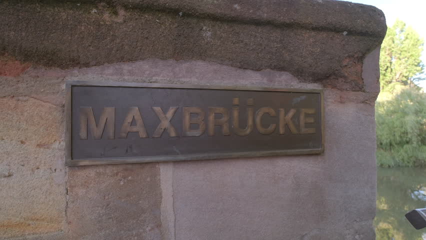 Camera slides from Maxbrucke to reveal Wasserturm in Nuremberg, Germany. Taken on a still summer day with reflections in River Pegnitz