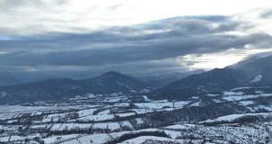 Winter 4k aerial video over a picturesque valley, with a gentle drone sweep revealing the majesty of snow-draped mountains under a soft dawn light, casting a tranquil spell. Carpathian Mountains. 