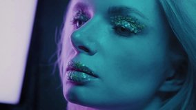 Close up is a beautiful blonde girl in a neon studio, dressed in a shirt. Beauty portrait of a woman's face. Female with plum lipstick. Clean skin, glitter with lips and eyes. Neon light in the club - Powered by Shutterstock - Get 15% off with code: PIKWIZARD15