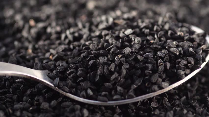 close-up of black cumin seeds falling in a heap on a spoon. slow motion. Asian food seasonings. black cumin seed harvest Royalty-Free Stock Footage #3417979573