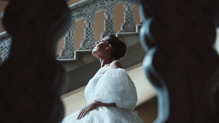Close-up portrait attractive young girl looking at the camera. Luxury fashion bride in a white dress.Young woman with beautiful hairstyle and makeup.