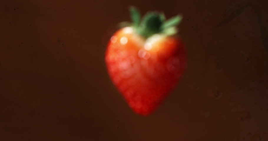Super slow motion macro of fresh ripe bio organic red strawberry fruit is falling in creamy melted liquid dark cocoa chocolate with splashing dripping drops at 1000 fps. Royalty-Free Stock Footage #3418094151