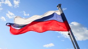 Low angle view of Russian national flag swaying on flagpole of sailing tourboat against blue sky with some white clouds. Soft focus. Real time video. Politic symbols theme.