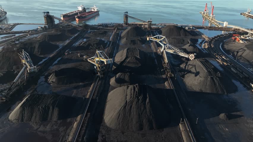 Piles of coal at USA port. Aerial flight above fossil fuel with environmental impact.