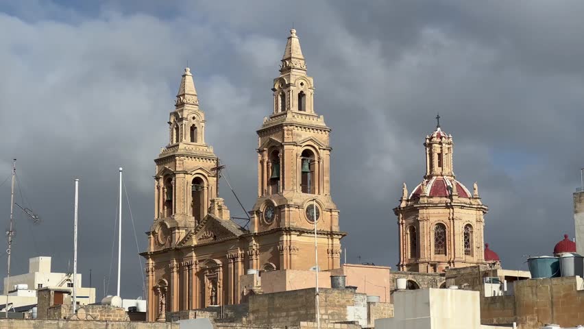Our Lady of the Sacred Heart Parish Church, Sliema, Malta: 4K shot showcases Neo-Gothic architecture against dramatic clouds. A good representation of Malta's architectural beauty.
