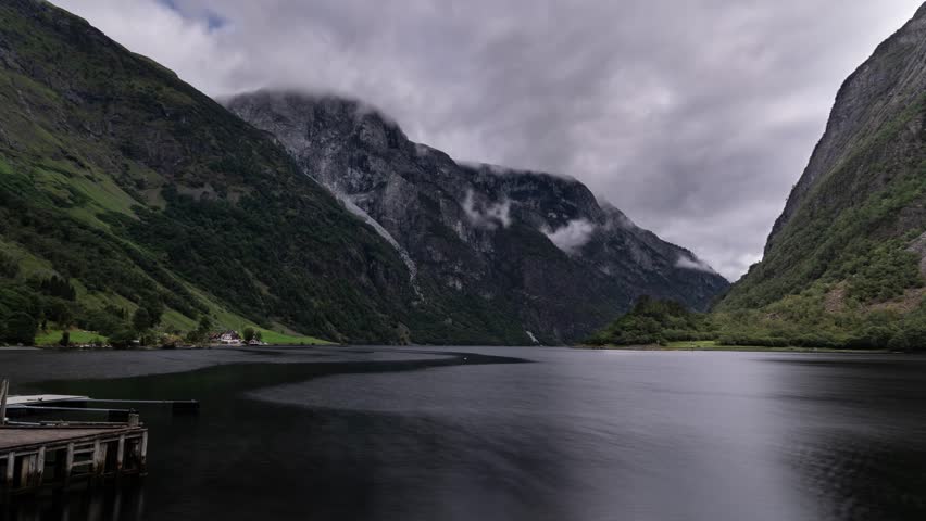 Timelapse of a Naeroyfjord in Norway, stormy clouds forming over the mountains, boats and ferries cruise fast as time passes. Royalty-Free Stock Footage #3418314027
