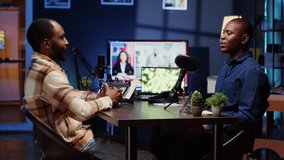 African american man invited to podcast, welcomed by friendly host, participating in entertaining discussion in studio. Cheerful guest fist bumping and saluting online comedy show presenter