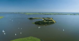 Many Sailboats on Dutch Lake Fluessen with an Artificial Island - Fluessen, Friesland, The Netherlands, 4K Drone Footage
