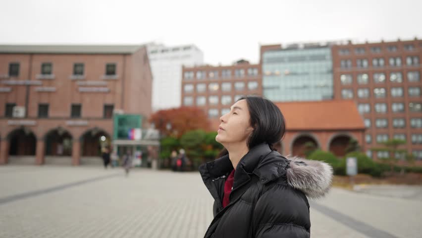 Slow-motion video of a long-haired Korean man in his 30s visiting a church in the cold winter in Myeong-dong, Seoul, South Korea