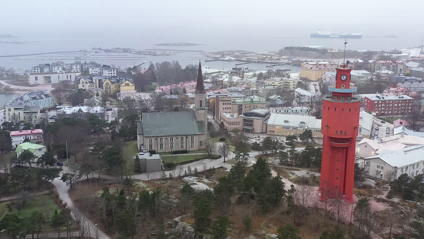 Hanko.Finland-January 3.2021: Beautiful aerial shot of Hanko Finland showing the church and the water tower with the port in the background. Aerial shot with the drone slowly moving sideways.