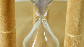 A footage of the sand runs out in the hourglass representing run out of time. time is passing, antique device for measuring time. close-up of sand running down through hourglass.