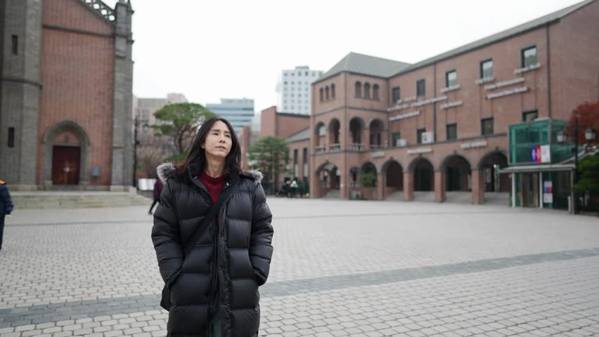 Slow-motion video of a long-haired Korean man in his 30s visiting a church in the cold winter in Myeong-dong, Seoul, South Korea
