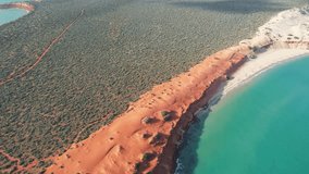 Video of Cape Peron from the sky. Aerial video of red and rocky land next to the beach and ocean in Francois Peron National Park, Shark Bay, Western Australia. Drone video.