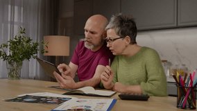 Focused attractive mature couple managing household finance, working with digital tablet , calculating expenses with calculator and planning family budget together at home. - Powered by Shutterstock - Get 15% off with code: PIKWIZARD15