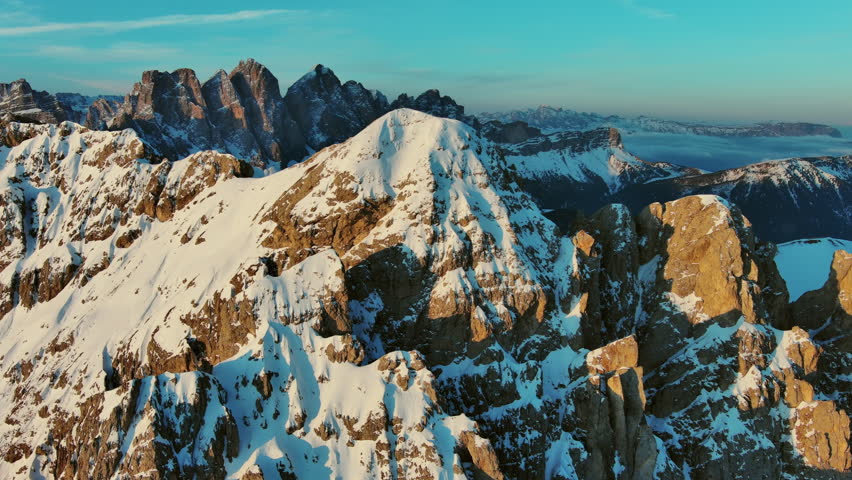 Aerial around view of amazing rocky mountains in snow at sunrise, Dolomites, Italy, 4k
