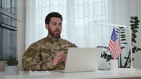 Confident military officer having video call on portable laptop near USA flag on desk. Bearded man participating in programs of humanitarian aid and support for social initiatives on distance. - Powered by Shutterstock - Get 15% off with code: PIKWIZARD15