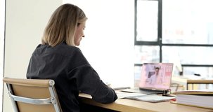 Businesswoman communicating with colleague via video call using laptop in office 4k movie. Remote work in business concept
