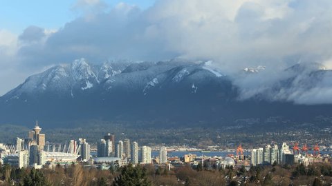 Cityscape and Grouse Mountain, Vancouver Timelapse. A time lapse view of downtown Vancouver, and the snow capped British Columbia Coast Mountains in Vancouver, British Columbia, Canada.