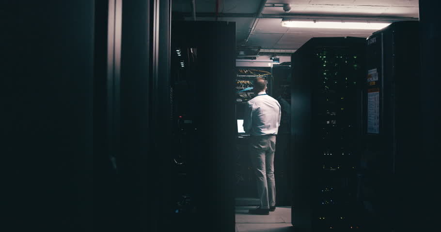 Man, data center and computer for maintenance, system solution and server room coding or cyber security at night. Back of technician with laptop engineering, gdpr software and backup or cables check Royalty-Free Stock Footage #3418574171