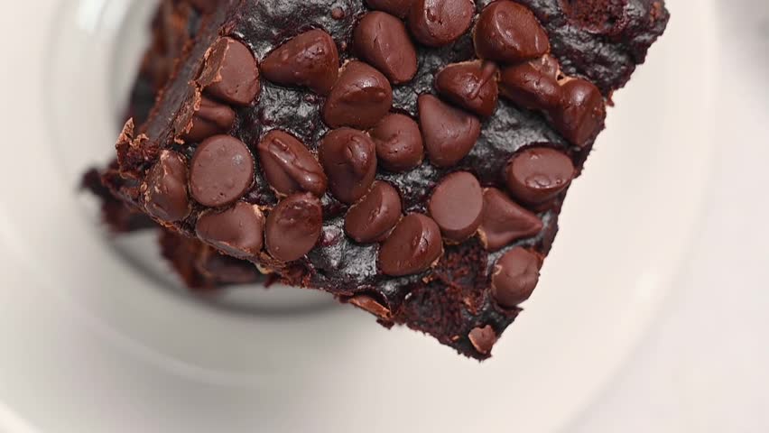 Top view homemade healthy flourless brownie squares with chocolate chips, vertical video
